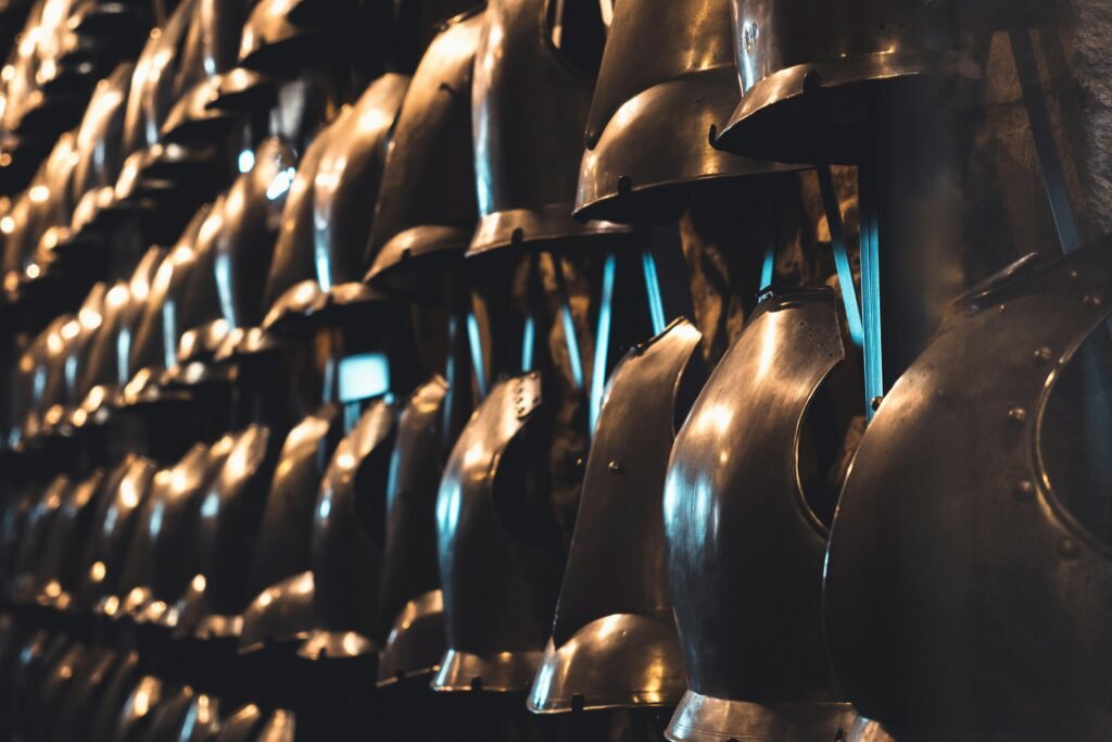 A collection of medieval knight helmets on display in a London museum, showcasing historical armor.