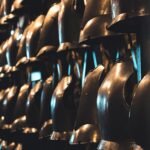 A collection of medieval knight helmets on display in a London museum, showcasing historical armor.