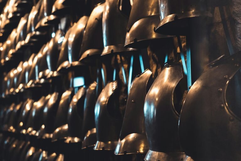 A collection of medieval knight helmets on display in a London museum, showcasing historical armor.