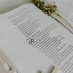 Close-up of an open Bible showing Psalm 60 with dried flowers.